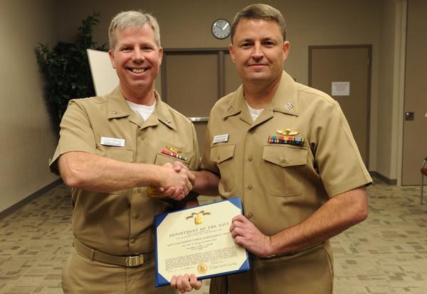 Rear Adm. Kirby Miller, left, presents a Navy and Marine Corps Commendation Medal to Cmdr. Van S.