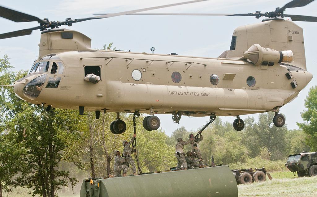 Engineer Soldiers from the 501st, 310th and 341st Engineer Companies brave strong winds to hook up bridge components to Chinook helicopters to be moved to the Arkansas River during River Assault