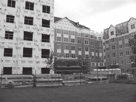 Figure 4: Privatized Unaccompanied Personnel Housing Project in Norfolk, Virginia A midrise building being constructed with noncombustible materials A separate housing unit built with wood-frame