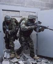 Two members of the adversary force simulate a breach of the Protected Area at a site during a training exercise. As with power reactor programs, full force-on-force inspection spans several weeks.