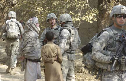 In these neighborhoods, the only thing a Soldier sees more than children is trash. Staff Sgt. Mark Maslon and U.S. linguist Amir talk to an elderly man who stepped outside his home, while Pvt.