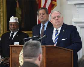 MARYLAND GOVERNOR AND TSCL CHAIRMAN ARTHUR COOPER TSCL Chairman Arthur Coop Cooper stands with Maryland Governor Larry Hogan and Secretary of Maryland V.A. George Owings during the announcement of the Governor s intent to remove taxes in military retired pay.