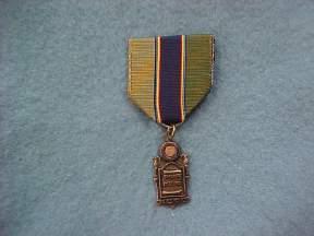 American Legion General Military Excellence Award: This award consists of a bronze medal accompanied by a ribbon with a distinctive miniature attachment depicting a torch.