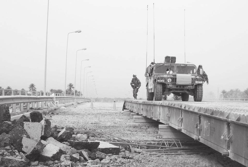 A HMMWV crosses a newly completed medium girder bridge at Objective Peach. into Baghdad.
