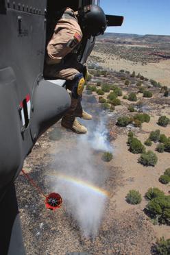 Colorado Army National Guard SSgt. Mark R. Belo drops 500 gallons of river water onto a wildfire burning the training range at Fort Carson, Colo., in June.