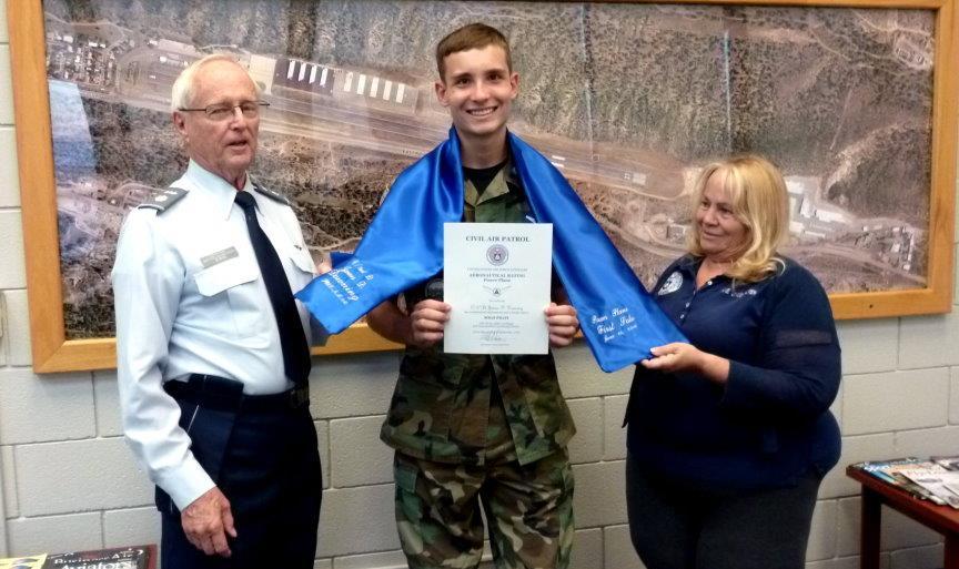Top: Cadet 2nd Lt. J.D. Downing (center) receives a certificate of recognition for his first solo from New Mexico Wing Director of Aerospace Education Lt. Col.