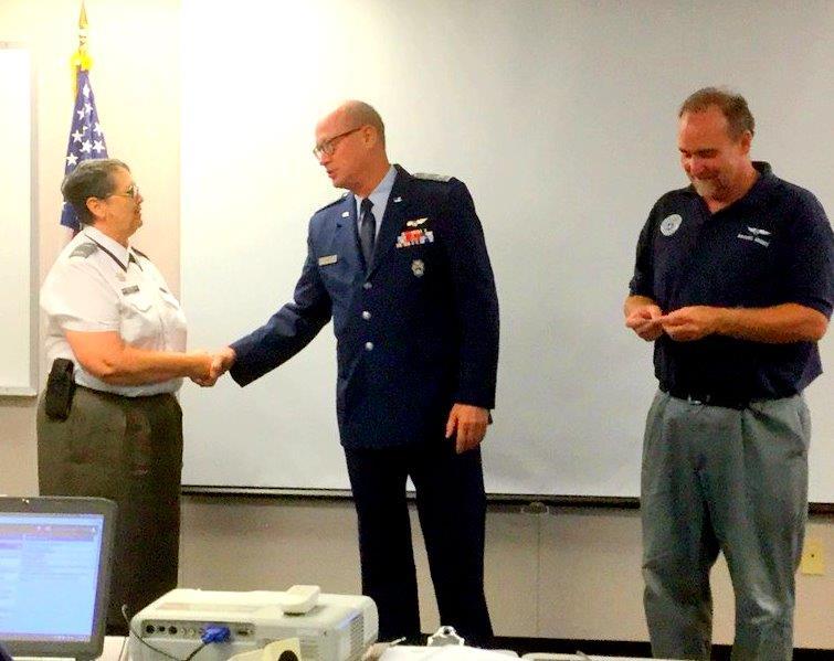 Top: (L-R): 1st Lt. Michelle Phillips, incoming commander of Las Cruces Composite Squadron, is congratulated by New Mexico Wing Commander Col. Mike Lee, as outgoing squadron commander Capt.