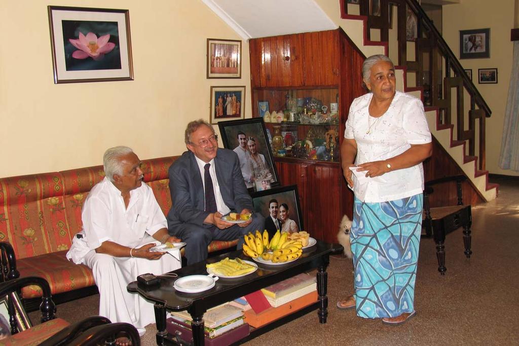 Mrs. Ariyaratne (right) entertaining Frank Brebeck (centre), PwC Germany and Sarvodaya Leader Dr. A. T. Ariyaratne (left) with Sri Lankan sweets after signing the MOU for Kosgama Project in May 2005.