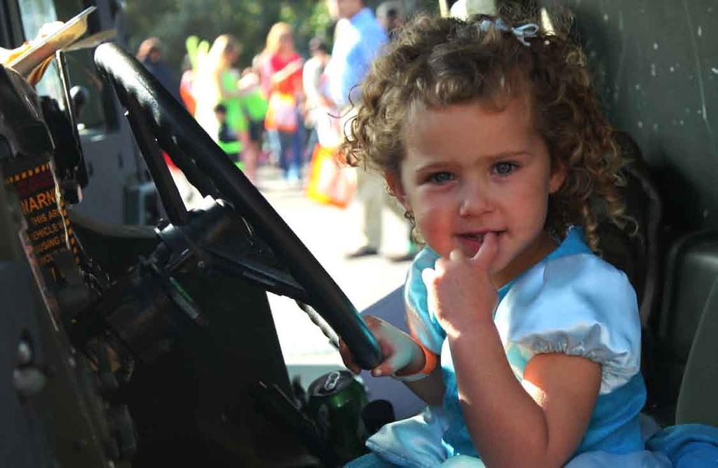 A young girl sits in the driver s seat of a Humvee at the 2011 Mission Bay Montessori Academy Halloween Carnival, San