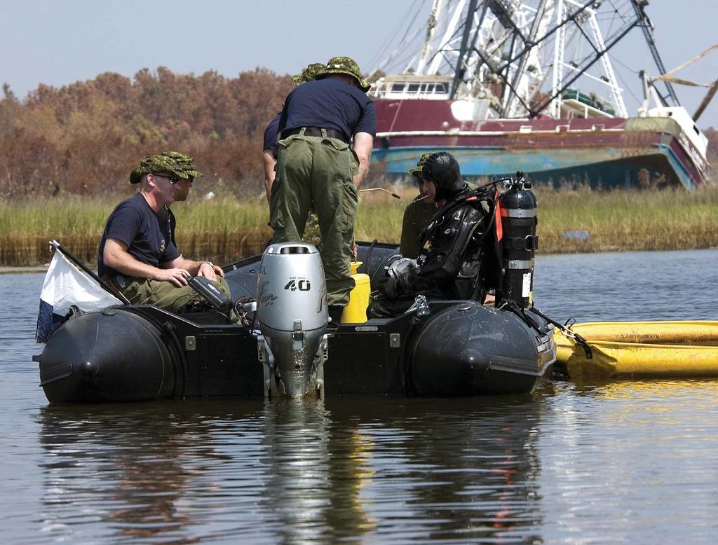 A Canadian Dive Team working under difficult conditions amid the devastation caused by Hurricane Katrina. US Navy ships.