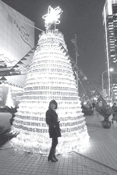 Trial operation showed the remote control A lady takes photo in front of a Christmas tree made of over 1,800 deserted bottles near the Shanghai Ocean Aquarium in Pudong District in Shanghai, east