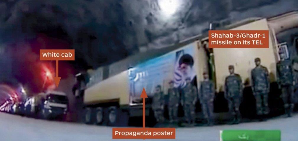 A Shahab-3/Ghadr-1 missile mounted on a TEL draped with a propaganda poster typical of those used in military parades in Tehran, suggesting that the underground tunnel complex is unlikely to house