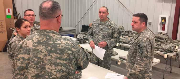 Indiana Army National Guard 1st Sgt. Norman King, holding paper and the military police task force s senior enlisted adviser, talks to his platoon sergeants at Camp Atterbury, Indiana, Tuesday, Jan.