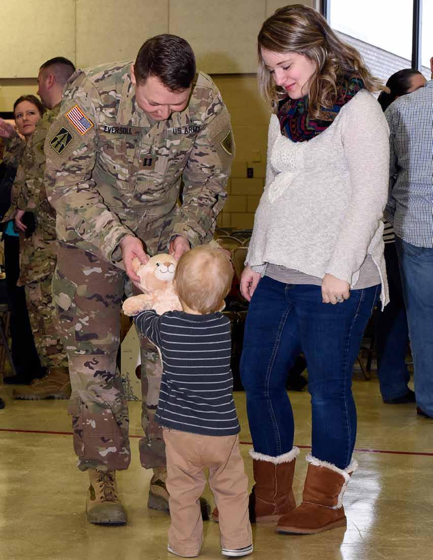Indiana Army National Capt. Alex Eversoll and his wife, Jessica, give their son, Judah, a teddy bear at a departure ceremony held in Indianapolis, Saturday, Jan. 14.