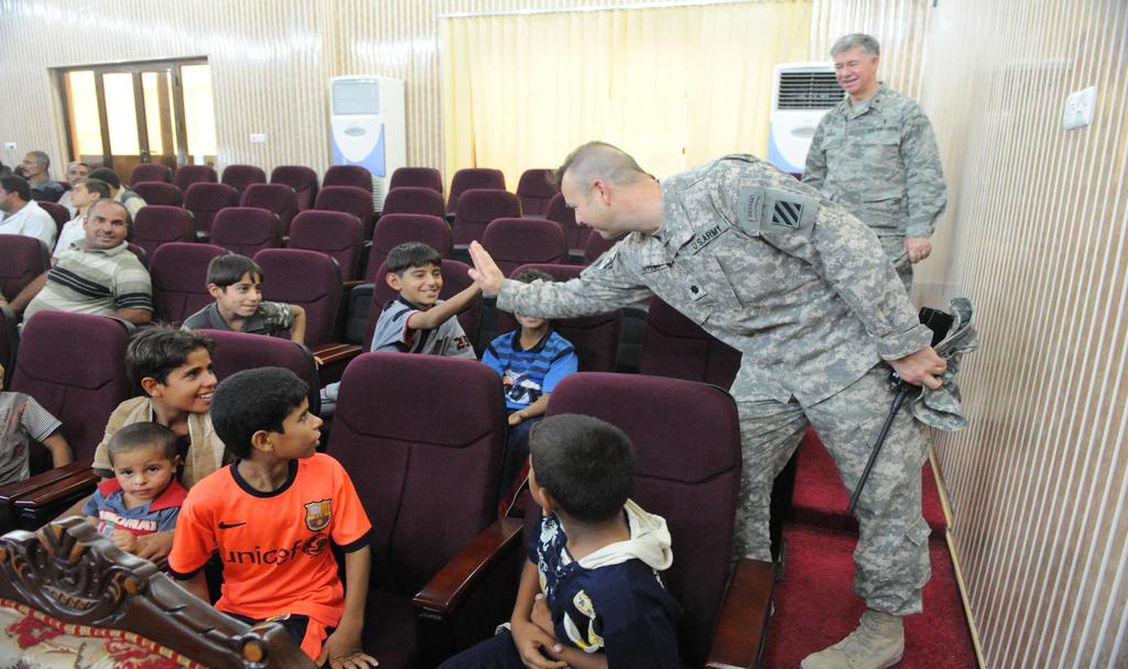 U.S. Army Lt. Col. Michael Taylor with Stability Transition Team, 4th Brigade, 3rd Infantry Division high fives Iraqi children during a humanitarian aid event in Ar Ramadi, Iraq, August 25, 2010.