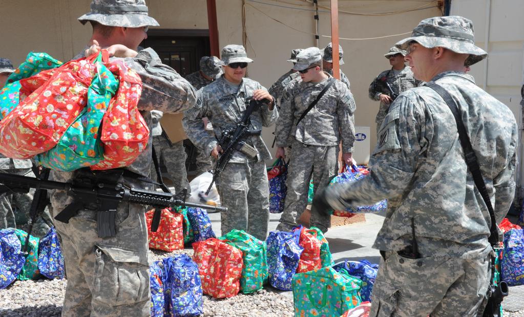 U.S. Army Soldiers with Stability Transition Team, 4th Brigade, 3rd Infantry Division (STT 4/3) gather bags to distribute to Iraqi families with the help of Iraqi Police in Ar Ramadi, Iraq, August
