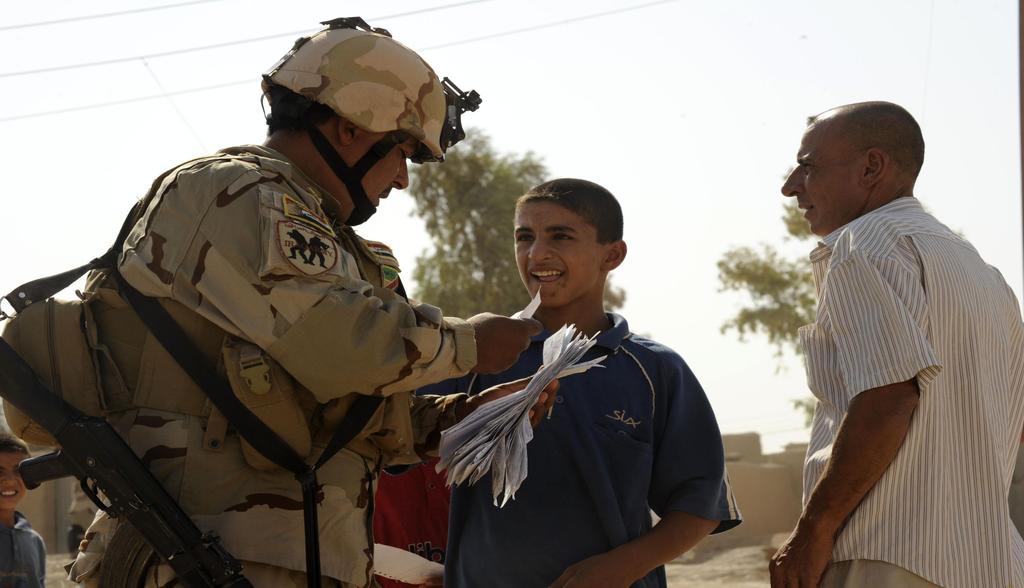 An Iraqi Army soldier collects ration cards from local Iraqis in a small village in Diyala Province, Iraq, September 4, 2010.