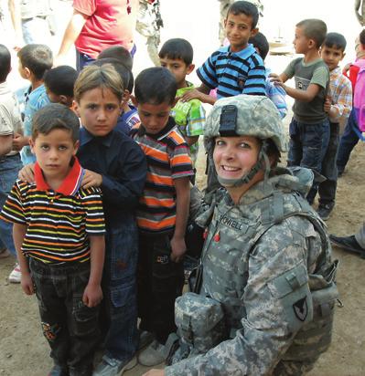 Then-MAJ Laura Powell, a member of the ASC Army Reserve Element and deployed to 1st Battalion, 402nd Army Field Support Brigade, in Iraq, visits with schoolchildren at a boy s grammar school in