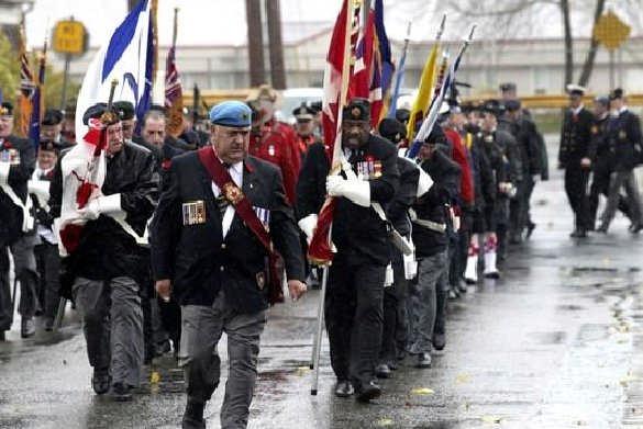 In nearby Sydney, Nova Scotia Remembrance Day Commander David Kane of Royal Canadian Legion Branch 138 leads veterans contingent through strong winds and rain in march to indoor services that were
