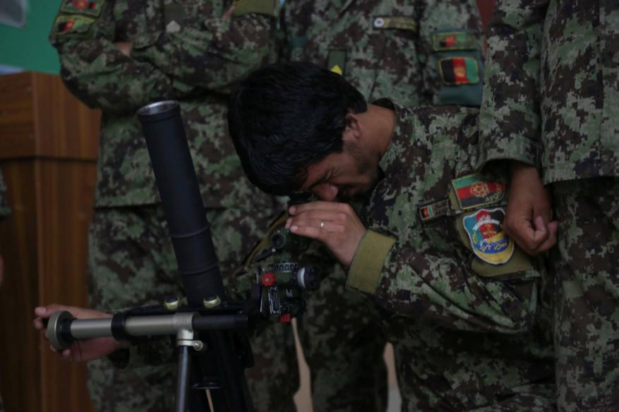 An Afghan National Army (ANA) soldier performs training objectives on the 60mm mortar tube during a simulated mortar training exercise at Forward Operating Base
