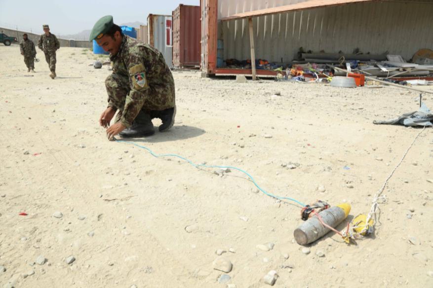 An Afghan National Army soldier, 201st Corps, performs a simulated detonation exercise on an Improvised Explosive Device (IED) during an explosive hazard reduction course at Forward