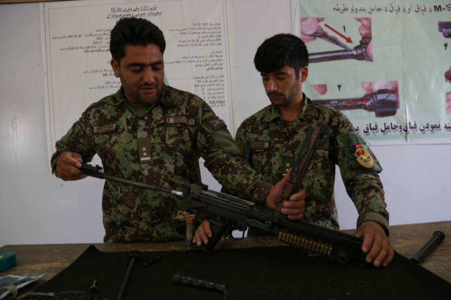 Afghan National Army soldiers with the 201st Corps, disassemble an M249 light machine gun during a weapons training course at Forward Operating Base Gamberi, Laghman