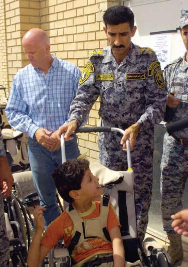 event, here, June 20. Lt. Col. Louis Zeisman, of Fayetteville, N.C., greets a handicapped Iraqi boy during a humanitarian event, June 20, at Joint  Paratroopers assigned to the 2nd Bn.
