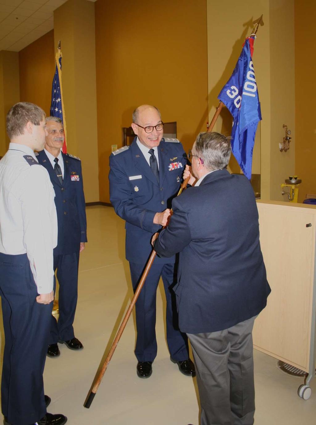 Top: Maj. Singluff (right) accepts command of the squadron from Wing Commander Col. Mike Lee. At left, outgoing Commander Maj. Glen Nicolet. (Photos: Lt. Col. Maria-Lisa M.