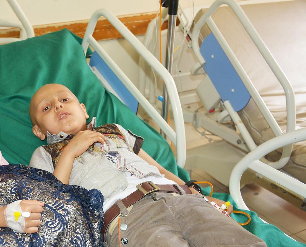 47 Akram, 8, and Ashjan, 7, a brother and sister, lie on one bed suffering from lymphoma and a brain tumour, respectively.