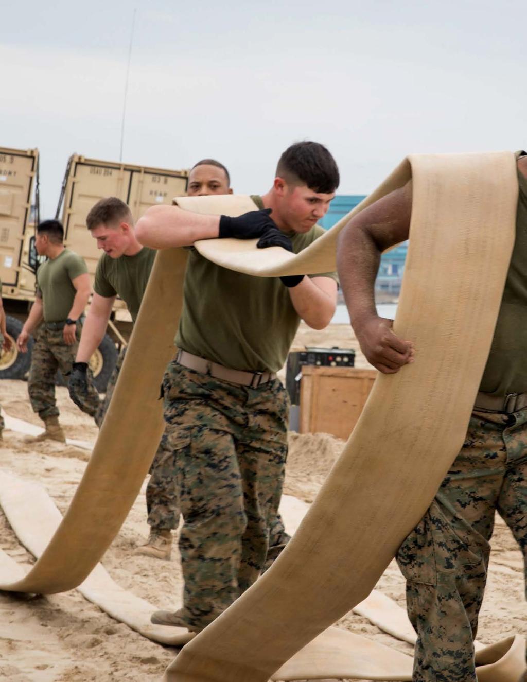 Marines attached to the 3rd Transportation Support Battalion, 3rd Marine Logistics Group, move a hose reel system