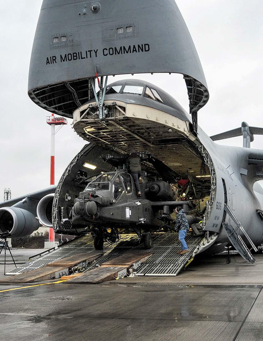 An AH-64 Apache helicopter is unloaded from an Air