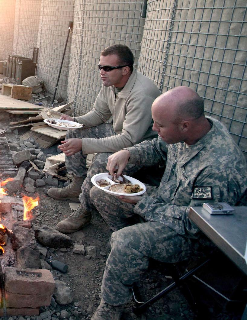 Soldiers deployed with D Company, 3rd Battalion, 509th Infantry Regiment, eat their Thanksgiving meal at Combat Outpost