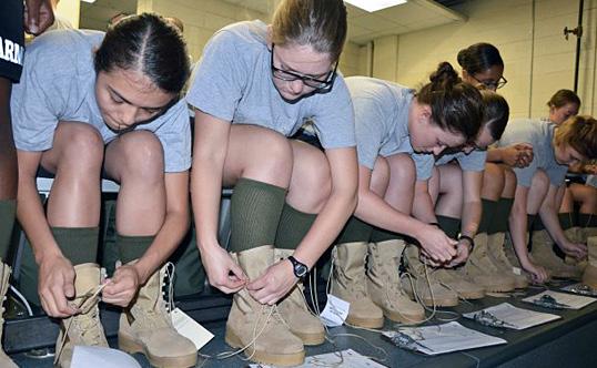 Recruits at Fort Jackson, South Carolina, lace up their new boots during basic training.