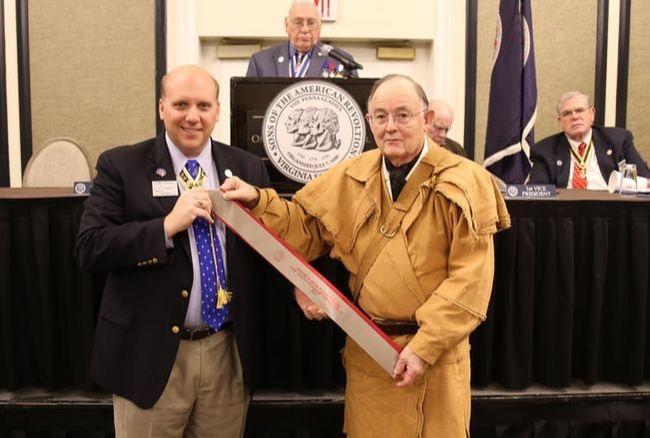VP Barry Schwoerer accepts the streamer for the