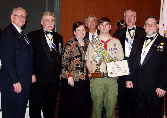 , poses with his parents and ALSSAR members after receiving the Eagle Scout Award at