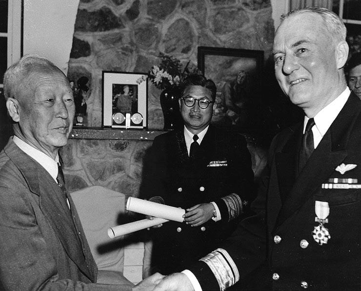 Syngman Rhee (left), president of the Republic of Korea (ROK), presents the ROK Order of Military Merit (Taiguk) to Rear Admiral Ralph A. Ofstie, U.S. Navy, Commander Task Force 77, in ceremonies at the presidential residence in Pusan, Korea.