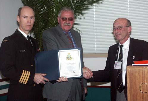 Pat Mordaunt (centre) of the Canadian Lifeboat Institution receives a commemorative certificate on the group s behalf from Captain Les Falloon (left) and the Canadian Coast Guard s Terry Tebb.