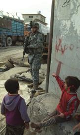 CPT Calvin Fisher, a 3rd ID project purchasing officer, surveys construction progress at a village community center. Above, SGT Ronald Railing, 1-9 FA, on patrol in Mosul.