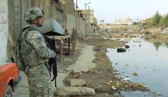 Left, SSG Flores checks a Mosul neighborhood flooded by sewage as a survey team makes an assessment to help the Iraqis fix the problem.