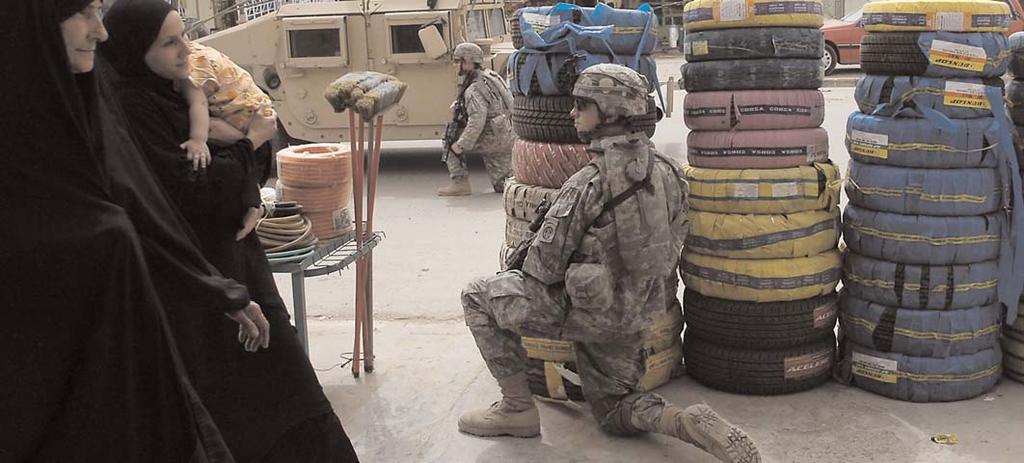 Justin Hovatter, both with Company, 2nd Battalion, 325th Airborne Infantry Regiment, 2nd Brigade Combat Team, 82nd Airborne Division, pull security during a patrol through the business district of
