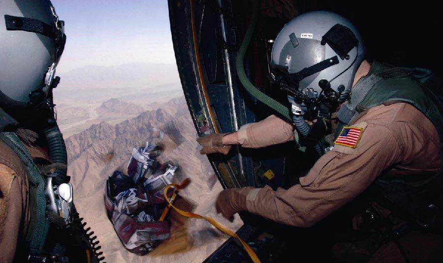 Top: Airman 1st Class Josh Huffman, a C-130 Hercules loadmaster, drops a box of 10,000 warning leaflets over the southeastern mountains of Afghanistan.