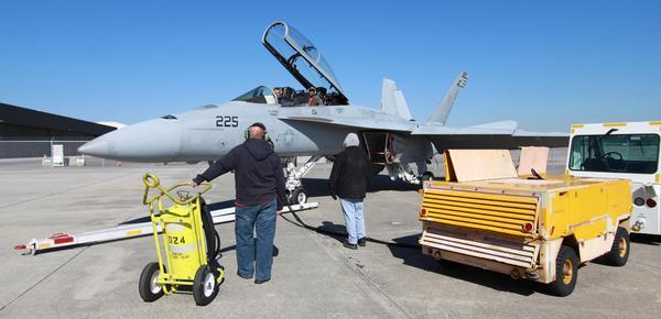Aircraft Systems Inspector Steve Zerbato fires up the twin engines of an F/A-18F Super Hornet, as Aircraft Mechanic Kirk Hale sits behind during a pre-induction maintenance inspection Dec. 9.