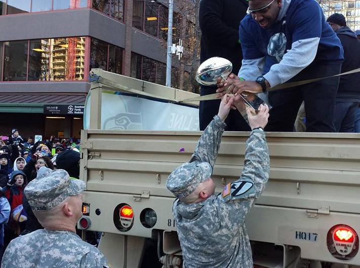 King King County SGM Kelly Pugh hands the Vince Lombardi Trophy to a Seattle Seahawks player during the Super Bowl victory parade on Feb. 7, 2014.
