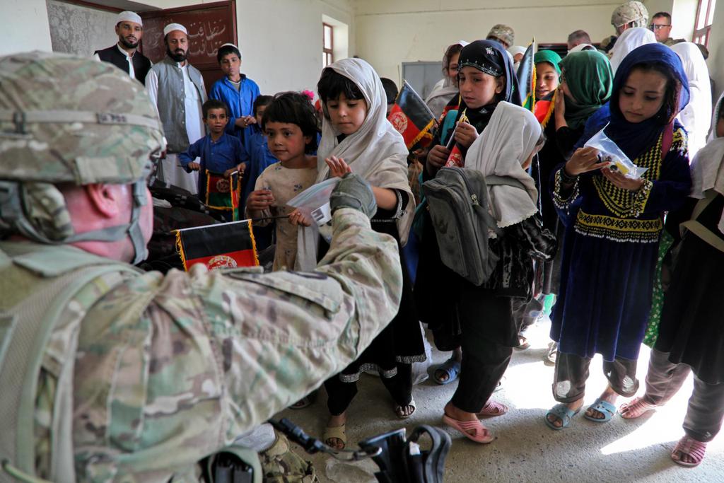 A young girl accepts candy being handed out by U.S. Army Maj.