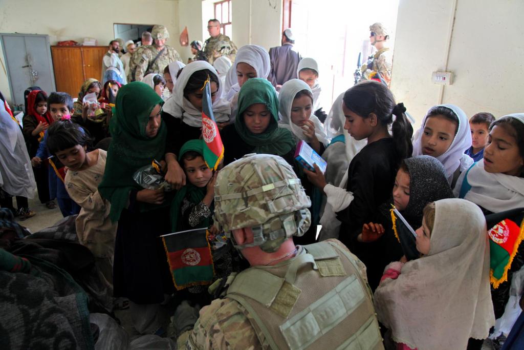 Young girls swarm around U.S. Army Maj.