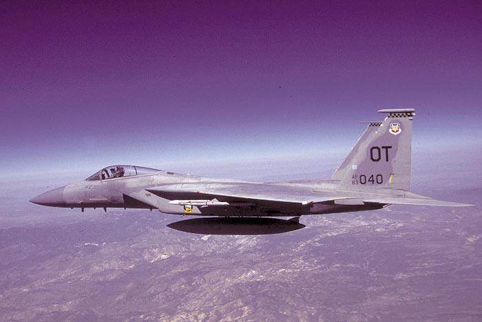Above, an AIM-9X is visible against a white-tipped AIM-120 AMRAAM, both mounted on an F-15C.