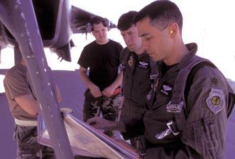 At right, an F-15E crew does the paperwork before a mission. The test and evaluation crews perform missions similar to what front-line crews might encounter.