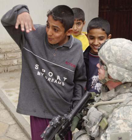 ) George Wallace as he talks with local school children as other Soldiers from the battalion search a school in a northern Baghdad neighborhood Feb. 15.