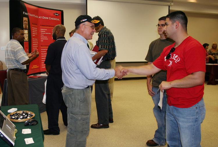 CHAMPION TECHNOLOGIES Champion Technologies Plant Trainer Rod Hauser (left) shakes hands with Alvin Community College Process Technology student Albert Ortiz, of Texas City, at the third annual ACC