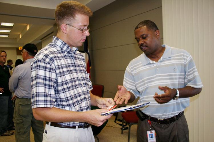 DOW CHEMICAL Dow Chemical representative Leavon Robinson (right) discusses careers opportunities with Mike Walston, of Alvin, at the third annual Alvin Community College Process Technology Open House